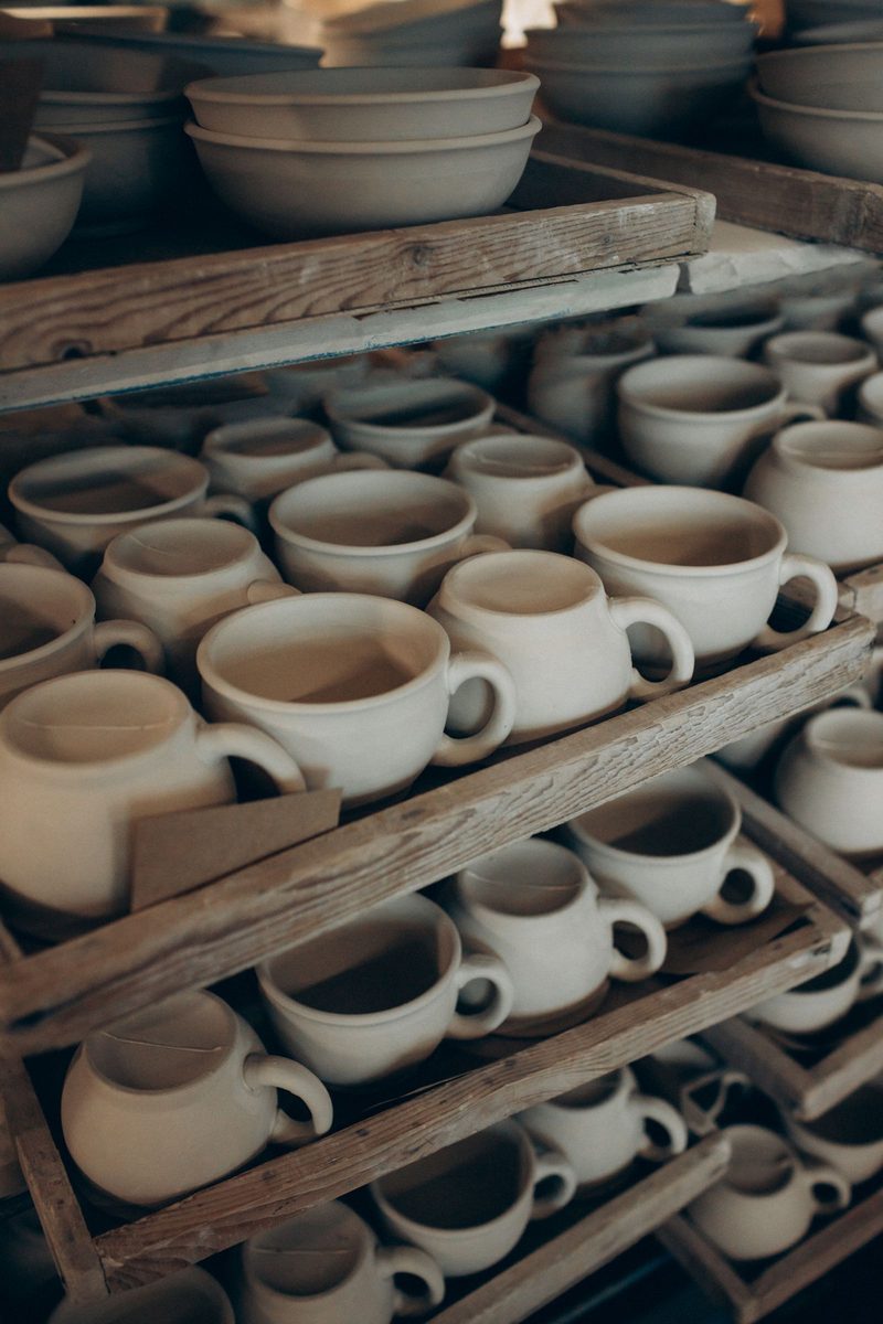 Rows of unglazed stoneware drying on wooden racks